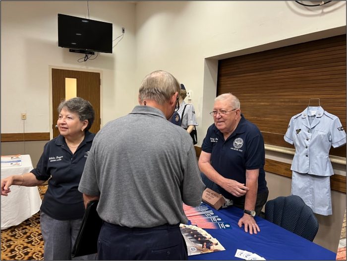 Volunteers at a display table showcasing the history of enlisted USAF Airmen.