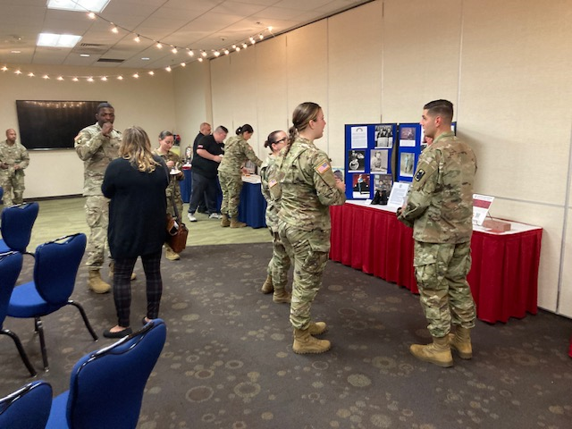 Attendees review collages and memorabilia during Women's Equality Day event at JBSA-Fort Sam Houston.